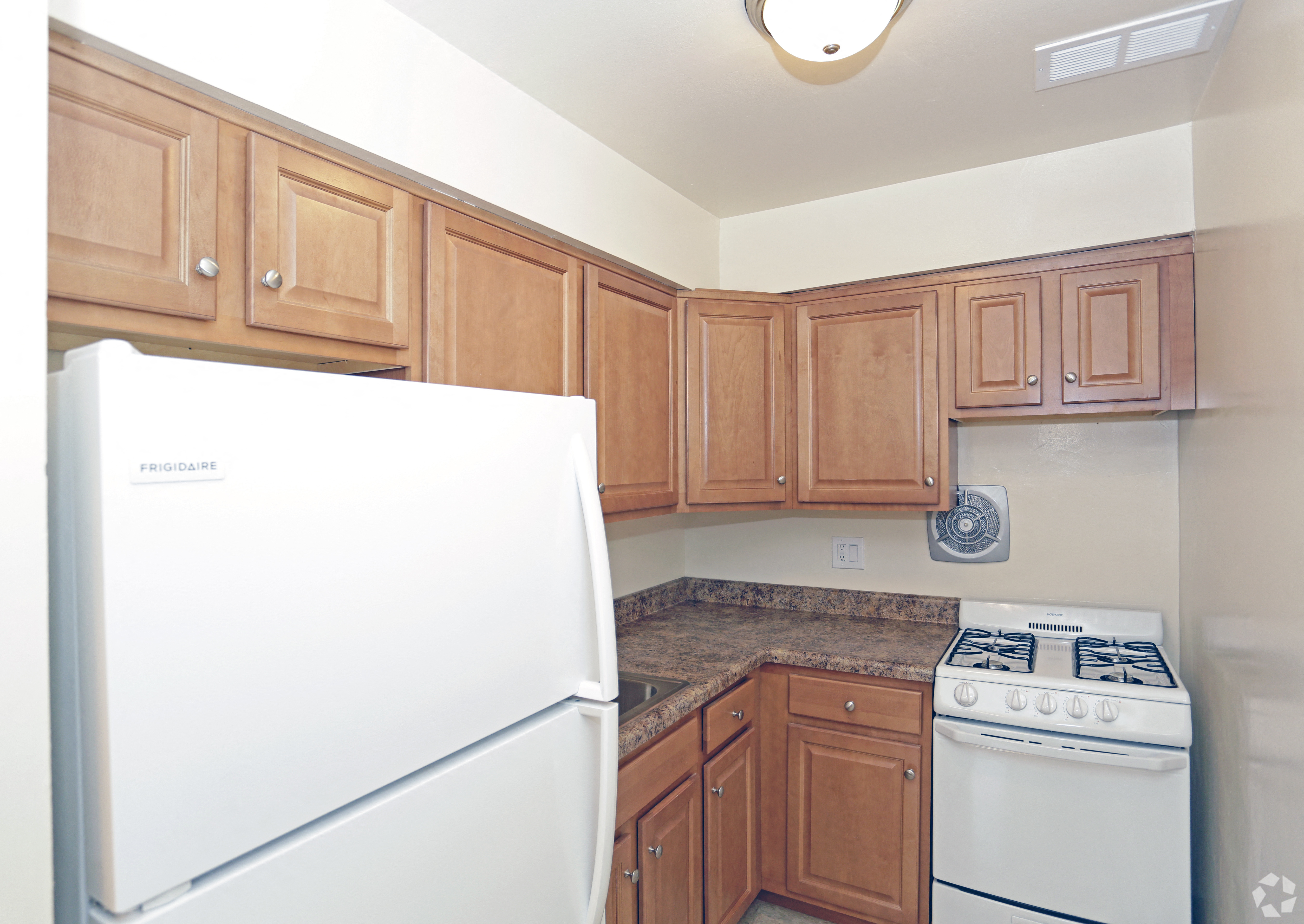 a kitchen with wooden cabinets and white appliances